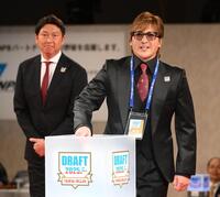 　抽選をする新庄監督。左は新井監督（撮影・堀内翔）