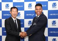 　中村良二監督（左）と握手を交わす大院大のエドポロ・ケイン（撮影・中田匡峻）