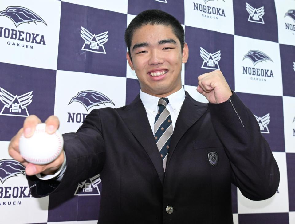 　オリックスから１位で指名され、笑顔で写真撮影する延岡学園・藤川敦也