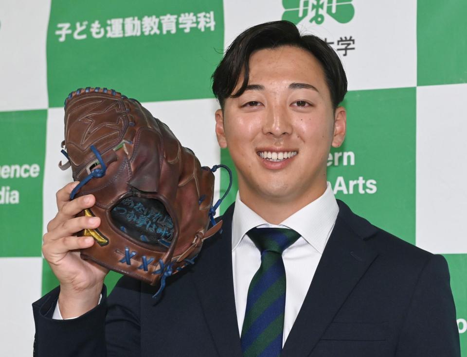 　オリックスに育成４位で指名され、祖母からもらったメッセージ入りのグラブを手に感激の仙台大・渡辺一生（撮影・開出牧）