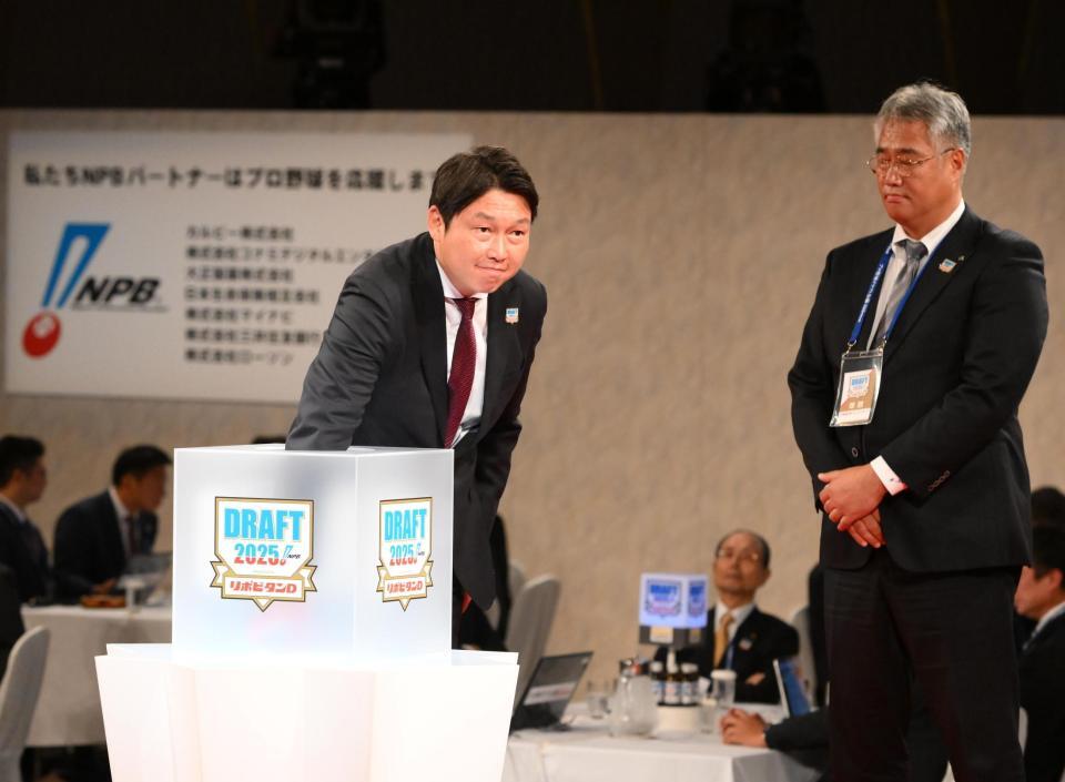 　仙台大・平川蓮の交渉権を獲得した新井監督。右は木田ＧＭ代行（撮影・堀内翔）