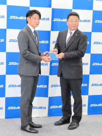 　吉村編成本部長（右）から阿部監督のサインが入ったドラフト会場のＩＤを贈られた巨人ドラフト１位指名の鷺宮製作所・竹丸