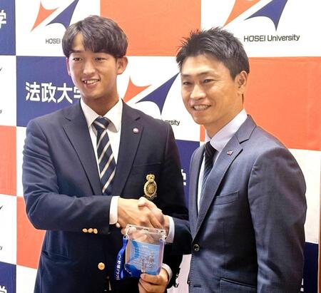 　青木ＧＭ特別補佐（右）から指名あいさつを受け、握手を交わす松下