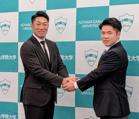　がっちり握手を交わす相川監督（左）とドラフト１位指名を受けた小田