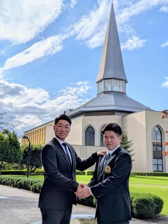 　チャペルをバックに握手する相川監督（左）とドラフト１位指名を受けた小田