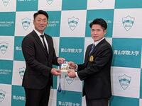 　相川監督（左）からドラフト会場のＩＤパスを贈られるドラフト１位指名を受けた小田