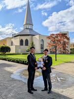 　青学大のチャペルをバックに記念撮影する相川監督（左）とドラフト１位指名を受けた小田