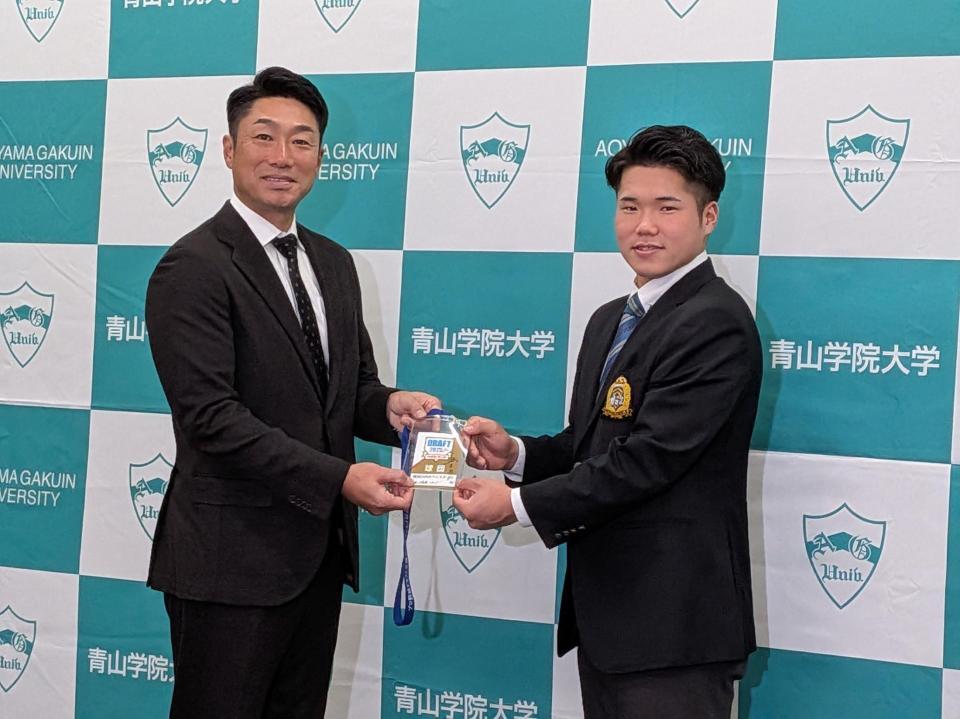 　相川監督（左）からドラフト会場のＩＤパスを贈られるドラフト１位指名を受けた小田