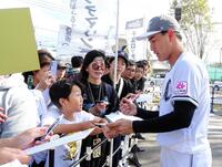 　練習を終えてファンにサインするロッテ・西川（右）