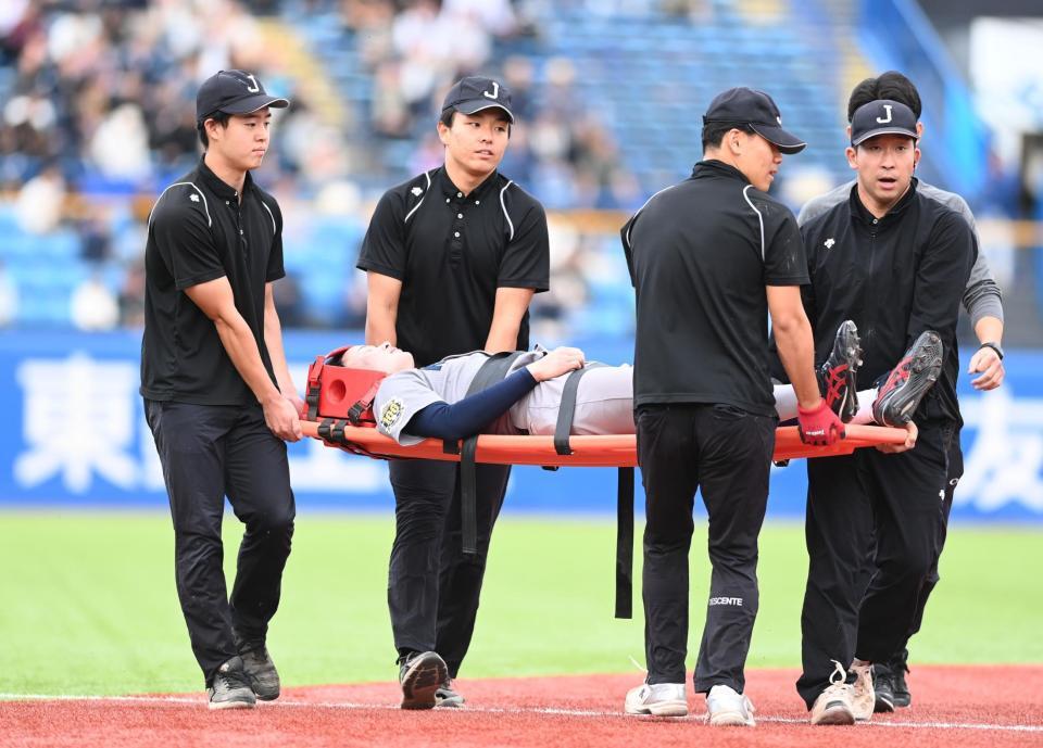　８回、担架で運ばれる丸田（撮影・園田高夫）