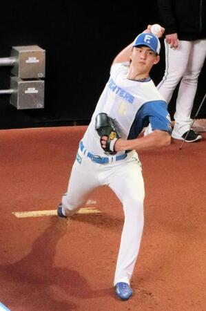 　ブルペンで投球練習をする達