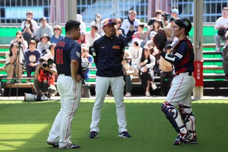 　ブルペンでの投球を終えて話し合う平良（左）と坂本（右）＝撮影・立川洋一郎