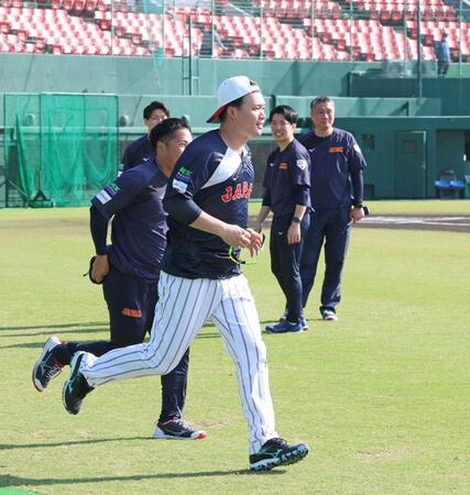 　野手が集合する円陣に遅れ、慌てて走って向かう森下（撮影・立川洋一郎）
