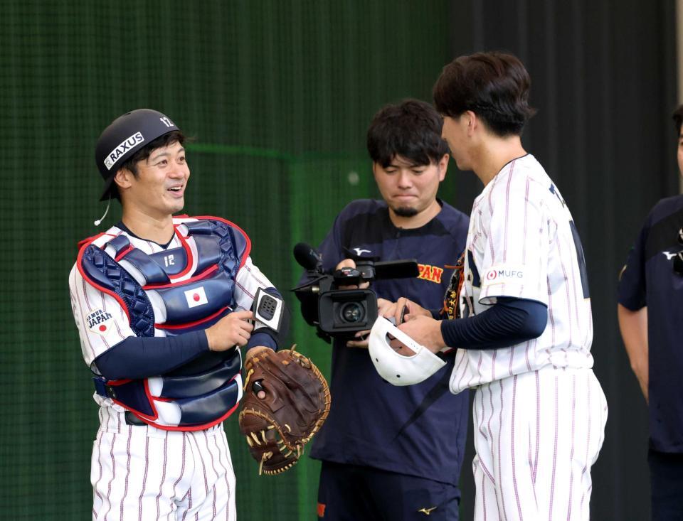 　ピッチコムを使って投球を終えた大勢（右）と話をする坂本