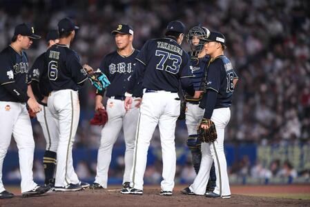 　オリックス・山本由伸（右端）は、高山郁夫コーチ（７３）からアドバイスを受ける＝２２年