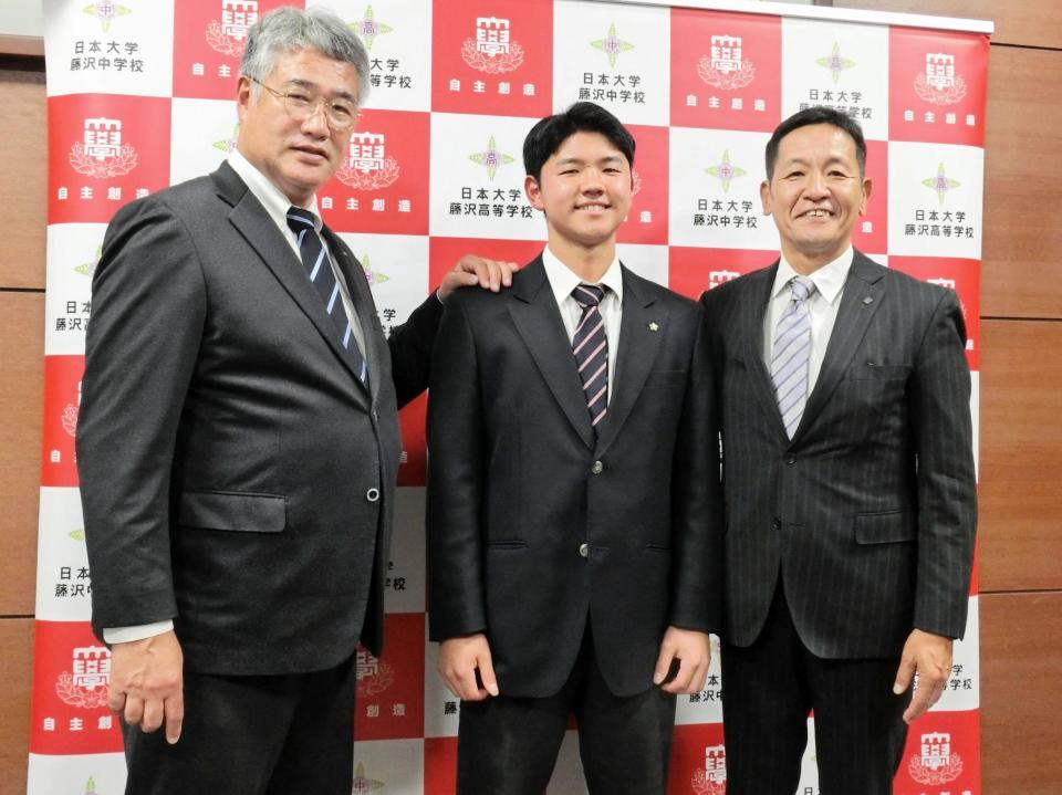 　日本ハムからドラフト４位指名され仮契約を結んだ日大藤沢・半田（中央）は、木田ＧＭ代行（左）と坂本スカウト（右）と笑顔を見せる