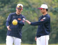 　隅田（左）からボールの握りのアドバイスを聞く森浦（撮影・立川洋一郎）