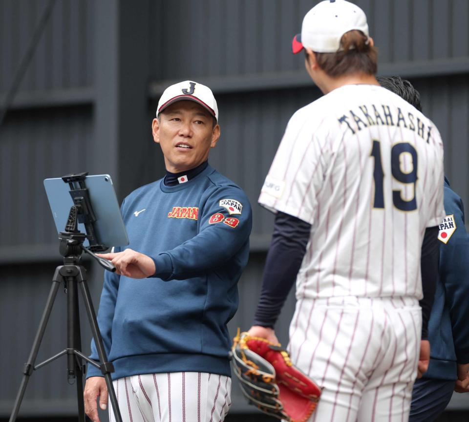 　ブルペンで高橋（右）の投球データを見て話しかける井端監督（撮影・立川洋一郎）