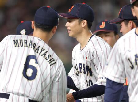 １回を無失点に抑え、ナインとタッチを交わす侍ジャパン・曽谷龍平＝東京ドーム（撮影・西岡正）