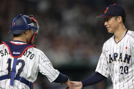 　３回を無失点に抑え、坂本（左）とタッチを交わす曽谷（撮影・西岡正）
