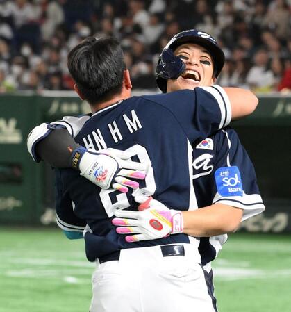 　４回、二者連続本塁打を放ち、安賢民（手前）と抱き合う宋成文（撮影・伊藤笙子）