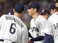 １回を無失点に抑え、ナインとタッチを交わす侍ジャパン・曽谷龍平＝東京ドーム（撮影・西岡正）