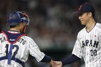 　３回を無失点に抑え、坂本（左）とタッチを交わす曽谷（撮影・西岡正）