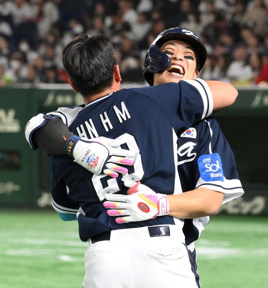 　４回、二者連続本塁打を放ち、安賢民（手前）と抱き合う宋成文（撮影・伊藤笙子）