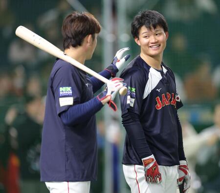 　小園（左）に肩をたたかれ、笑みを浮かべる森下（撮影・西岡正）