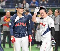 　試合前の打撃練習で牧（右）と談笑する岡本