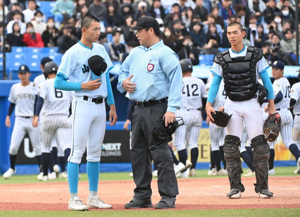 　野沢球審に監督の伝言を伝える山梨学院・桃木瀬凪（左）＝撮影・持木克友