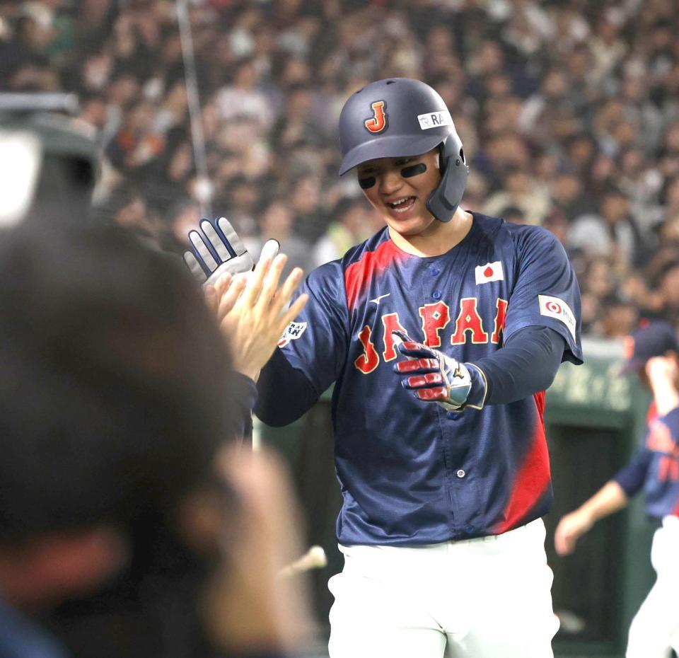 　４回、佐々木の適時打で生還し、ナインとタッチを交わす森下（撮影・西岡正）