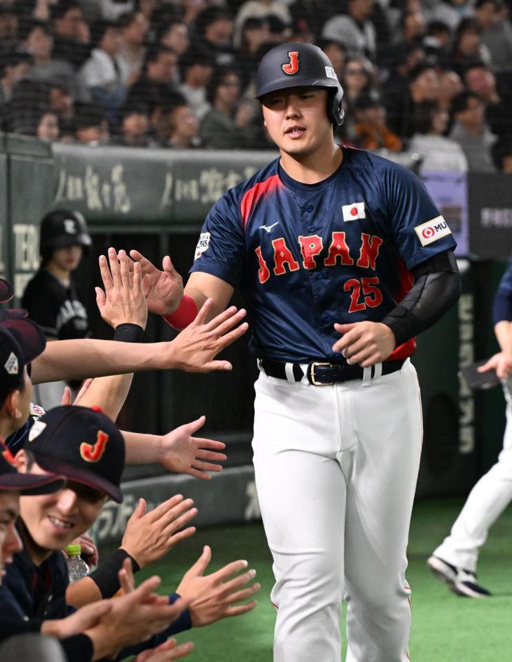 　８回、森下の押し出し四球で生還し、タッチを交わす岡本