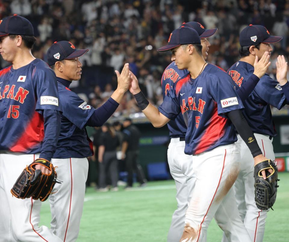 　韓国と引き分け、井端監督（左）とタッチを交わす佐々木（撮影・西岡正）