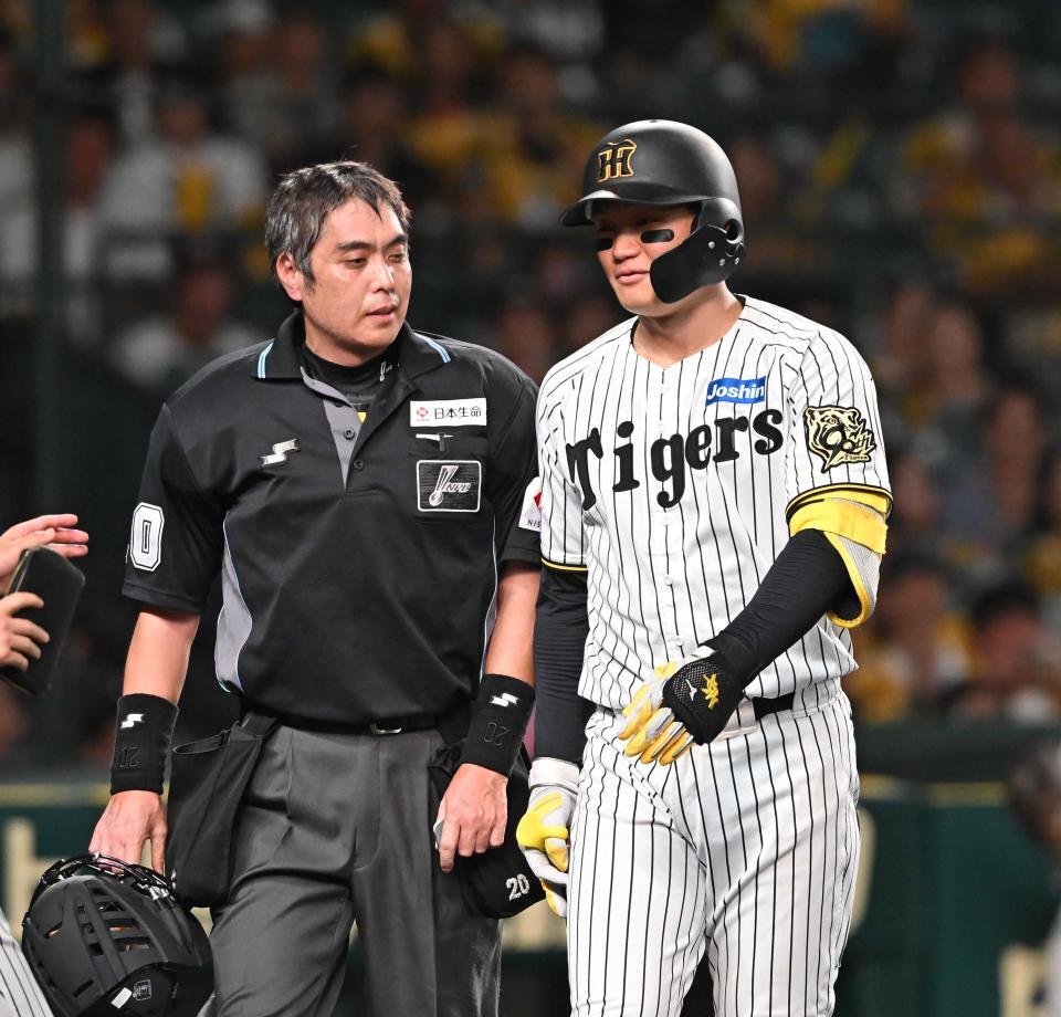 　見逃し三振に倒れた阪神・森下（右）は白井一行球審と言葉を交わす＝９月２６日