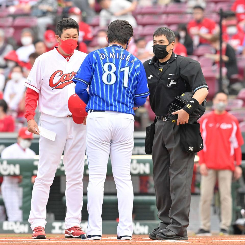 　メンバー表を交換する白井一行球審＝２２年５月６日