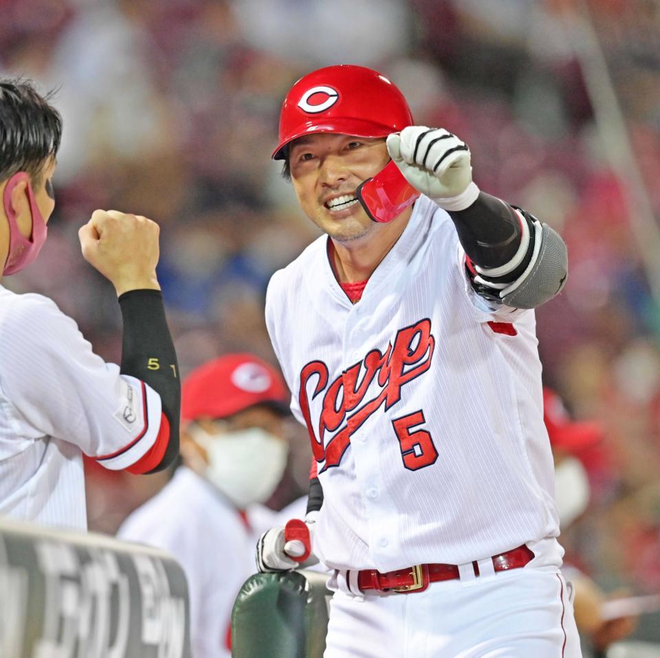 　ソロを放って生還しナインの出迎えに応える広島・長野久義＝２１年