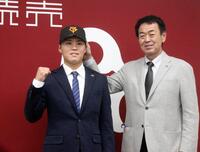 　巨人への入団記者会見でポーズをとる川原田（左）と水野編成本部長