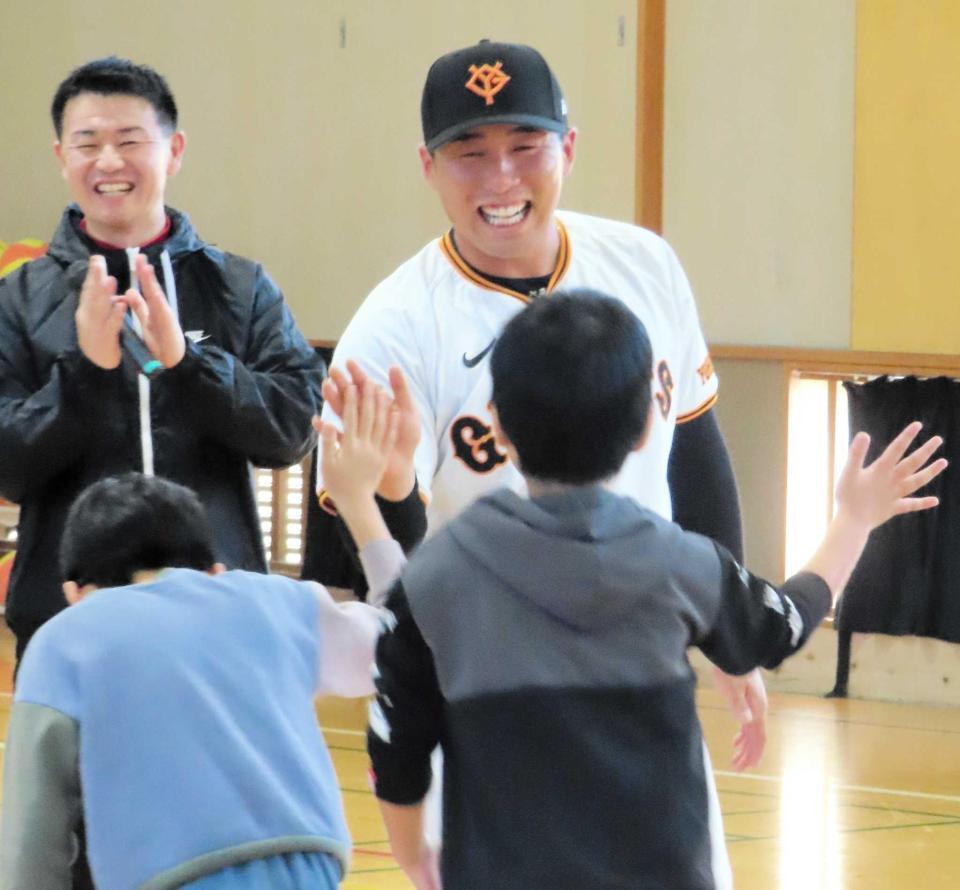 　子供たちと笑顔でタッチを交わす浅野（撮影・中田康博）
