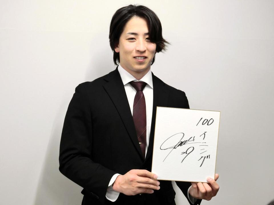 　契約を更改し、来季の目標を記した色紙を手にする細野