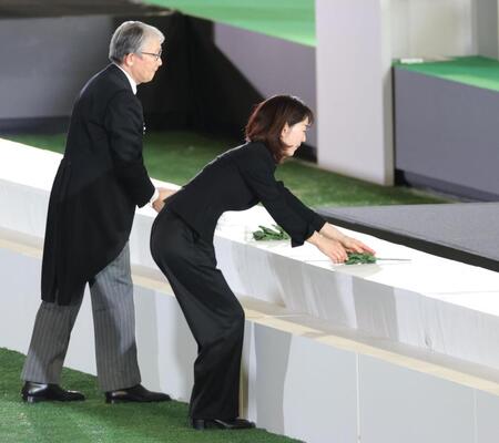 　献花を捧げる長島三奈さん（右）＝撮影・西岡正