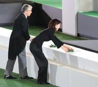 　献花を捧げる長島三奈さん（右）＝撮影・西岡正