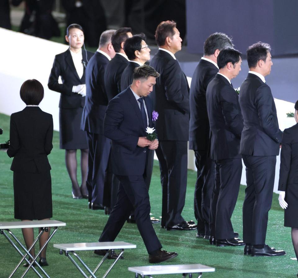 　献花に向かう鈴木（撮影・西岡正）