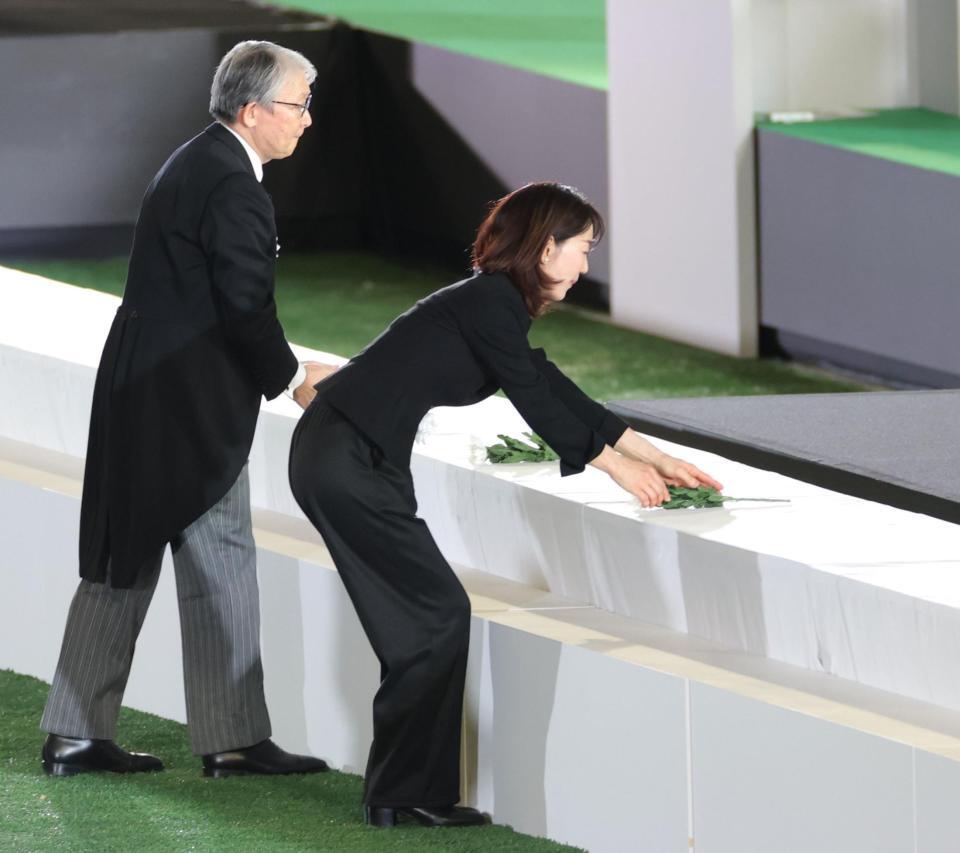 　献花を捧げる長島三奈さん（右）＝撮影・西岡正