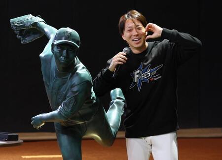 　９００試合登板の等身大立像と記念撮影に応じる宮西（撮影・中島達哉）