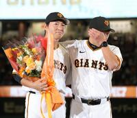 　長野久義氏（左）に花束を渡し、涙する阿部監督（撮影・西岡正）