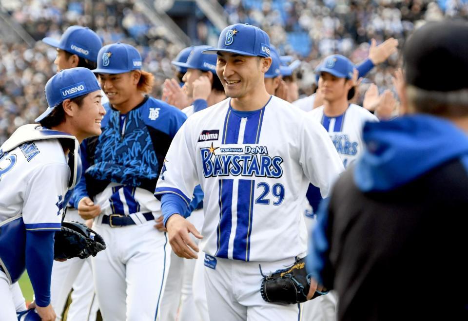 　打者１人を三振に仕留め、笑顔でベンチに戻る伊藤（中央）＝撮影・佐藤厚