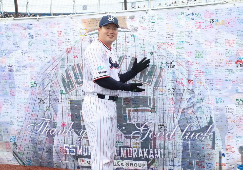 　メッセージボードの前で笑顔を見せる村上（撮影・佐々木彰尚）