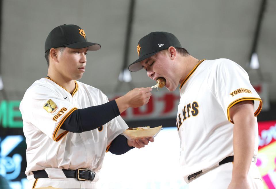 　グルメ対決で大城卓（左）からたこ焼きを食べさせてもらうリチャード（撮影・西岡正）