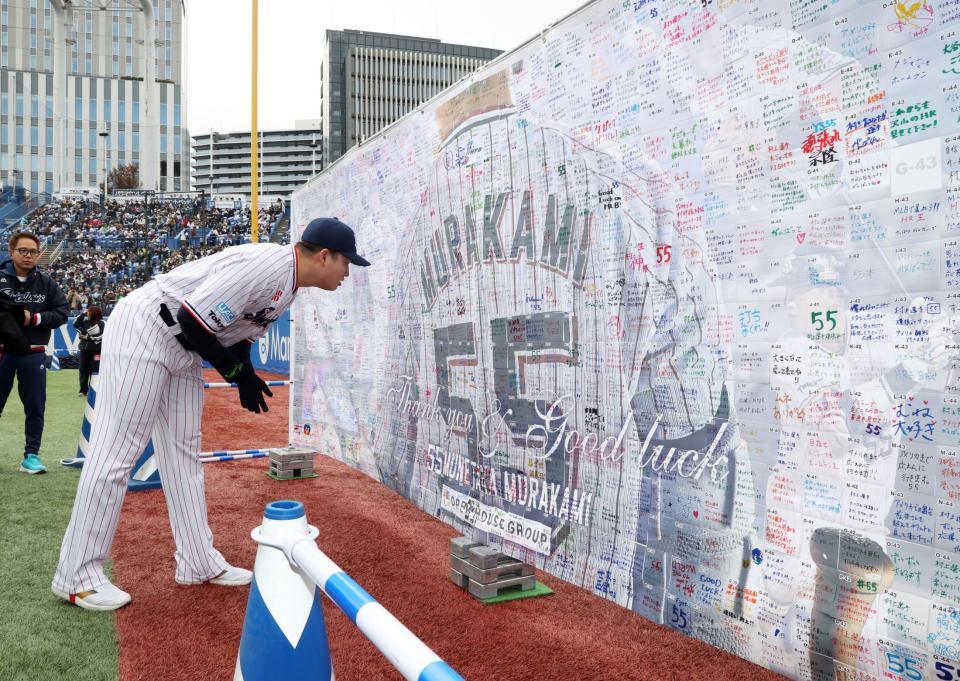 　応援メッセージが書かれたボードを見つめる村上